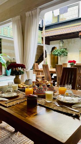 a wooden table with food and candles on it at Riad Dalla Santa in Marrakech