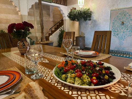 une table avec un bol de légumes sur une table dans l'établissement Riad Dalla Santa, à Marrakech