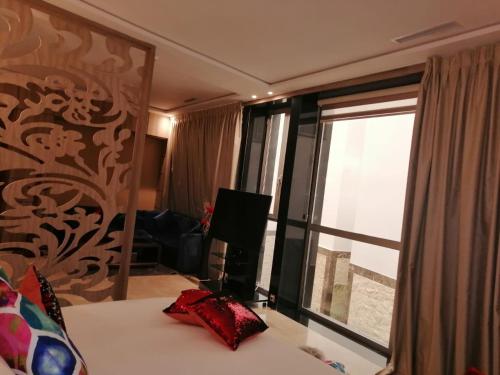 a bedroom with a bed and a large window at Hôtel Volubilis Meknès in Meknès