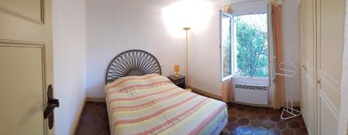 une petite chambre avec un lit et une fenêtre dans l'établissement Mas Saint Jaume, à Cavalaire-sur-Mer