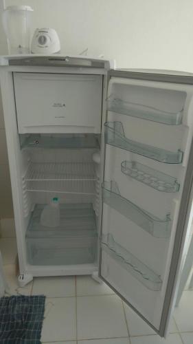 an empty refrigerator with its door open in a kitchen at Kitnet Clokel ap 104 A in Jacumã