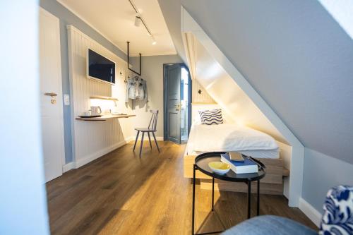 a small room with a bed and a table at Ual Öömrang Wiartshüs in Norddorf