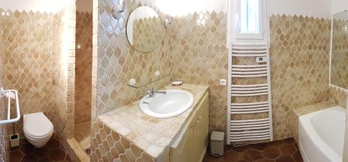 une salle de bain avec un lavabo et des toilettes dans l'établissement Mas Saint Jaume, à Cavalaire-sur-Mer
