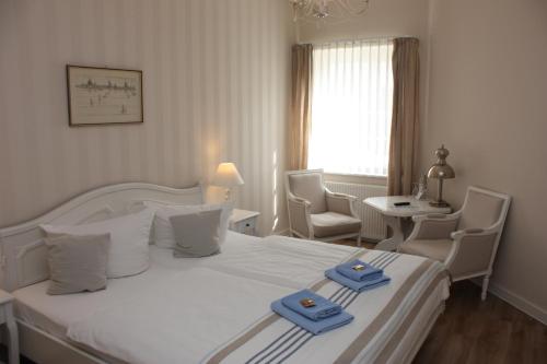 a hotel room with a bed with two towels on it at Hotel Maria in Greifswald