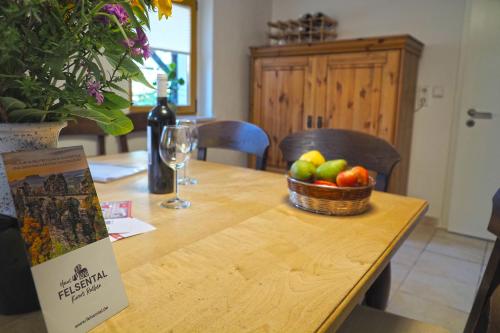 a table with a basket of fruit and a bottle of wine at Haus Felsental in Rathen