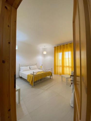 a bedroom with a bed and a yellow curtain at Villa Vistasalentina Piano terra in Torre Colimena