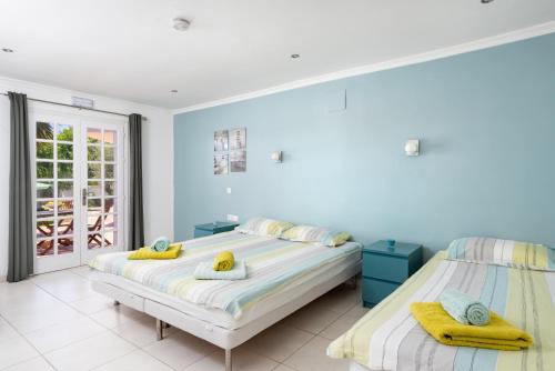 2 Betten in einem Schlafzimmer mit blauen Wänden in der Unterkunft Casa Caleda in Mijas Costa