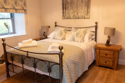 a bedroom with a bed with a metal bed frame at Slatehouse Cottage, Drumlanrig in Thornhill