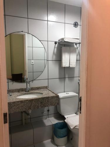 a bathroom with a sink and a mirror and a toilet at Gran Lençóis Flat in Barreirinhas