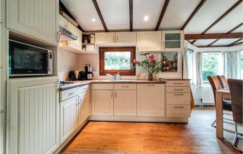 a kitchen with white cabinets and a sink at Stunning Home In Sint-Annaland in Sint Annaland