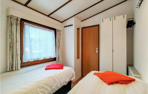 a room with two beds and a window and a door at Stunning Home In Sint-Annaland in Sint Annaland