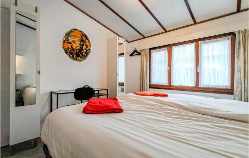 a bedroom with a bed with two red pillows on it at Stunning Home In Sint-Annaland in Sint Annaland