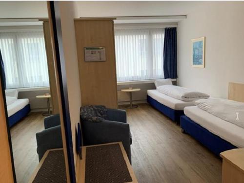 ein Hotelzimmer mit 2 Betten und einem Spiegel in der Unterkunft Hotel Blumenstein Self-Check In in Frauenfeld