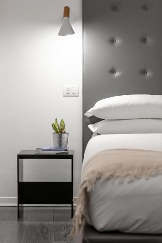 a bedroom with a bed and a table with a plant on it at N - SPACE modern guestrooms in Rome