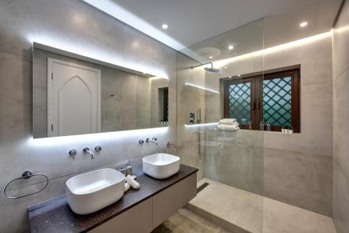 een badkamer met een wastafel en een glazen douche bij Durrani Homes - Arabian luxury at Souk Al Bahar besides Burj Khalifa & Dubai Mall in Dubai