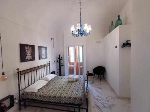 a bedroom with a bed and a chandelier at Casa Annita, casa vacanza in stile Sicilia, in pieno centro a Pachino in Pachino