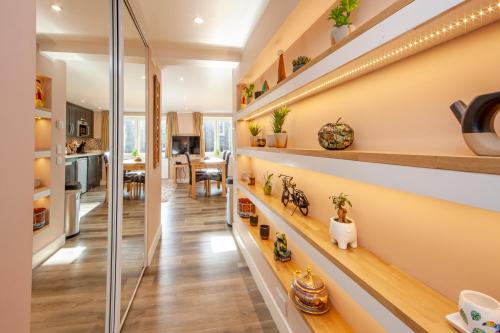 a home hallway with shelves with plants and a kitchen at Premium Studio Apt “C” in Oban