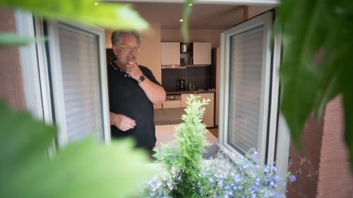 a man standing in a kitchen looking in a mirror at DAUSCH-GAESS-TROEG-Komfort-DZ-im-ehem-Ziegenstall-der-Hofstallung in Marktheidenfeld