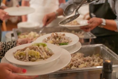 a group of people holding plates of food on a buffet at Hotel Posta in Aprica