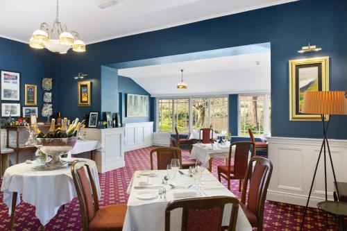 a dining room with tables and chairs and blue walls at Gougane Barra Hotel in Ballingeary