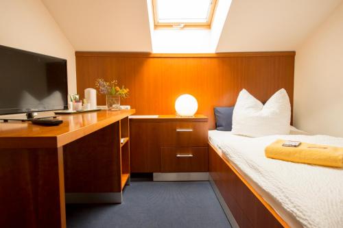Schlafzimmer mit einem Bett und einem Schreibtisch mit einem TV in der Unterkunft Pension Freiraum Guesthouse Berlin in Berlin