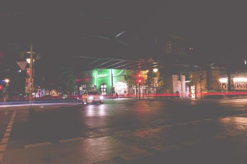 a car driving down a city street at night at Pension Freiraum Guesthouse Berlin in Berlin