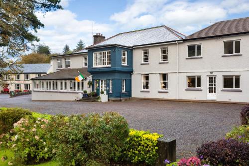 a blue and white house with a large driveway at Gougane Barra Hotel in Ballingeary