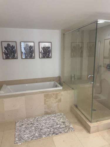 La salle de bains est pourvue d'une baignoire et d'une douche en verre. dans l'établissement IconBrickell Tower 3 W Residences, à Miami