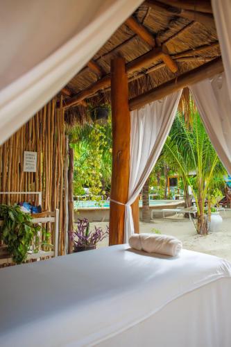 a bedroom with a bed with a white canopy at Holbox Deluxe Wellness Apartments in Holbox Island