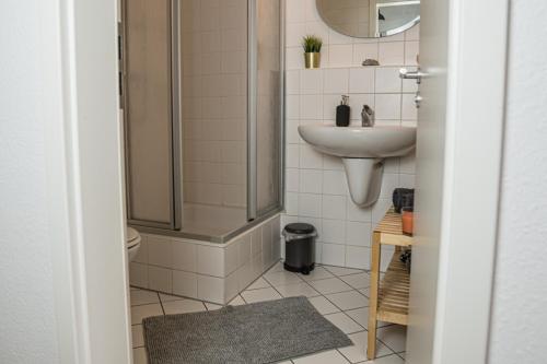 uma casa de banho com um chuveiro e um lavatório. em FULL HOUSE Studios - Southern Prime Apartment em Leipzig