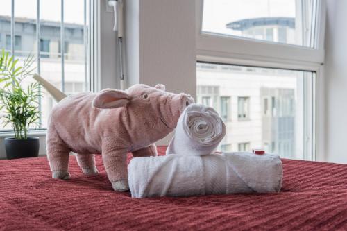 um elefante de peluche ao lado de um rolo de papel higiénico em FULL HOUSE Studios - Southern Prime Apartment em Leipzig