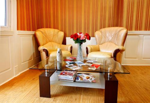 a living room with two chairs and a glass table at Sanata in Tbilisi City