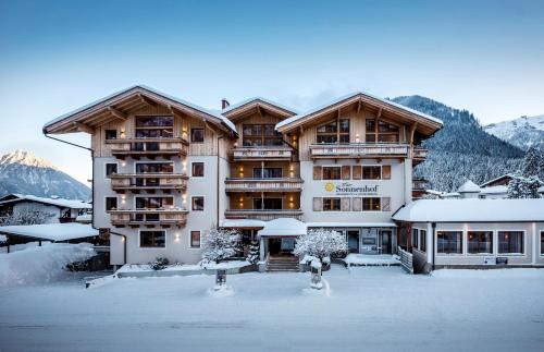 a large building with snow in front of it at Sonnenhof Genusshotel & Appartements in Pertisau