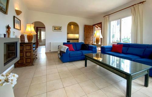 モライラにあるLa Madrugada - Luxury Moraira Villa With Sea Views and Private Heated Poolのリビングルーム(青いソファ、暖炉付)