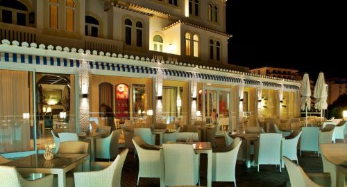 a restaurant with white chairs and tables and a building at Bela Vista Hotel & Spa - Relais & Chateaux in Portimão