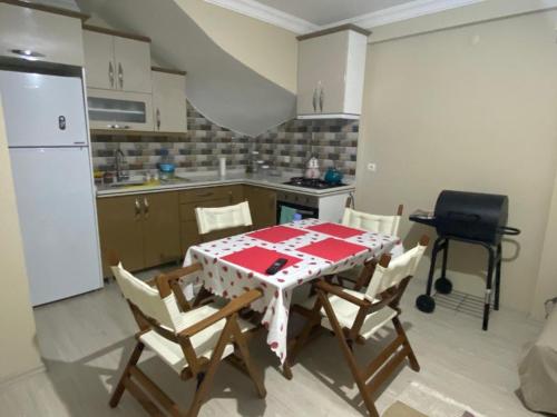 a kitchen with a table and chairs and a refrigerator at Çandarlı little sweet house in Dikili