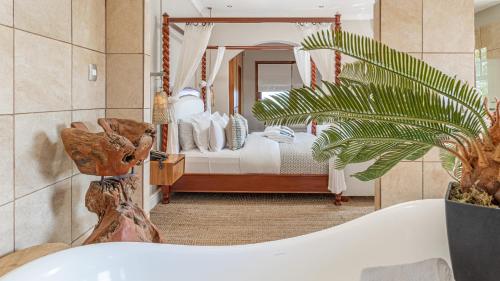 1 dormitorio con 1 cama y baño con bañera. en The Glen Boutique Hotel & Spa, en Ciudad del Cabo