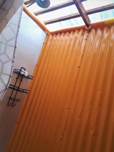 a room with a yellow wall and a window at Blue Space Beach Shack in Hibberdene