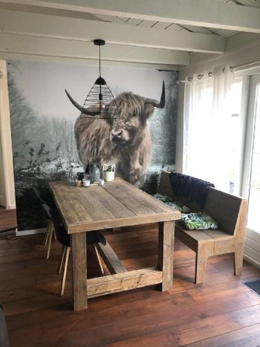 a painting of a bull on a wall in a living room at Vakantieverhuur Bienvenue in Boyl