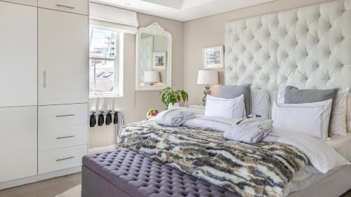 a bedroom with a large bed with a large headboard at The Glen Boutique Hotel & Spa in Cape Town