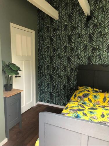 a bedroom with a bed and a green and white wall at Vakantieverhuur Bienvenue in Boyl