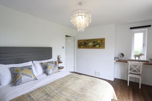 Un dormitorio con una cama grande y una lámpara de araña. en Northumberland-Hideaways en Kielder