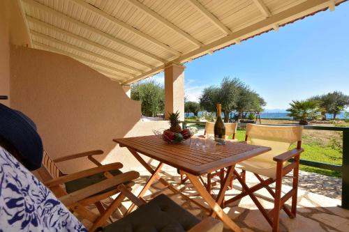 a wooden table and chairs on a patio at Renata Rooms & Studios in Barbati