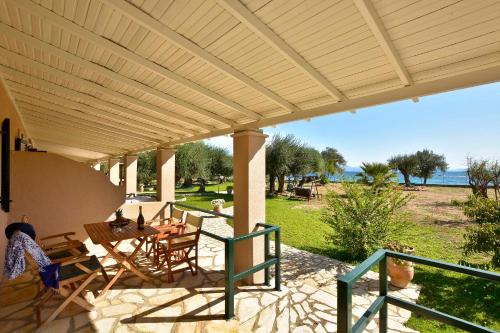 a patio with a table and chairs under awning at Renata Rooms & Studios in Barbati