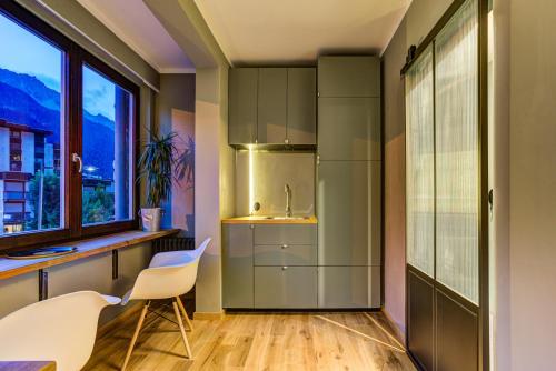 - une cuisine avec un évier, une table et des chaises dans l'établissement Chamonix City Center Luxury Studio Apartment, à Chamonix-Mont-Blanc