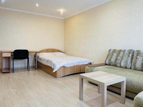 ウフタにあるАпартаменты на Ленинаのベッド、ソファ、テーブルが備わる客室です。