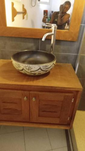 a bathroom sink with a bowl on a wooden counter at Villa Teranga Saly Sénégal in Saly Portudal