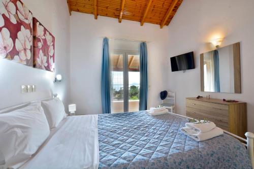 a bedroom with a large bed and a television at Renata Rooms & Studios in Barbati