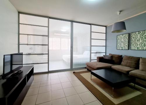 a living room with a couch and a table at The Studio at Sathorn Terrace in Bangkok