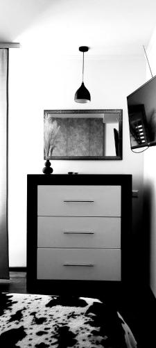 a dresser in a living room with a mirror at Немного Лондона в центре Чернигова in Chernihiv